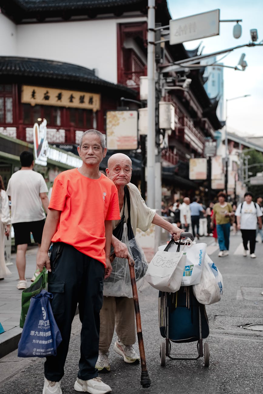 Two elderly men carry shopping bags along a bustling urban street, embodying a vibrant city life scene.