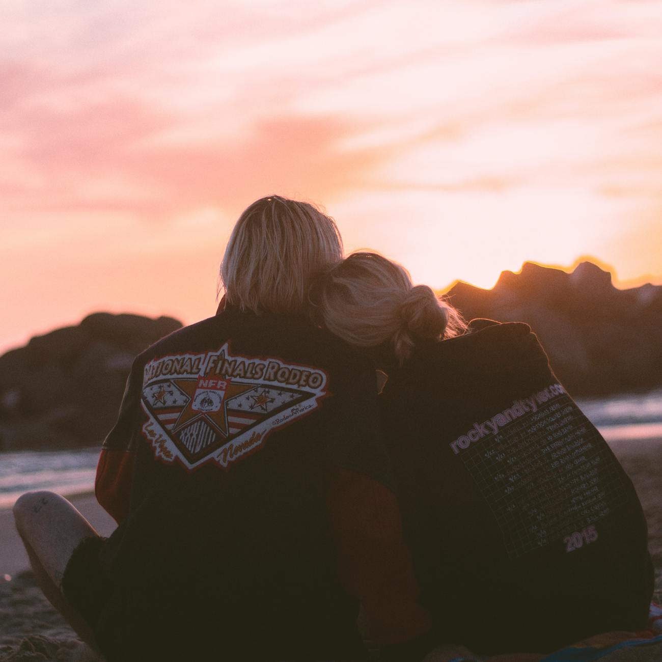 A couple embraces on the beach during a romantic sunset, symbolizing love and togetherness.