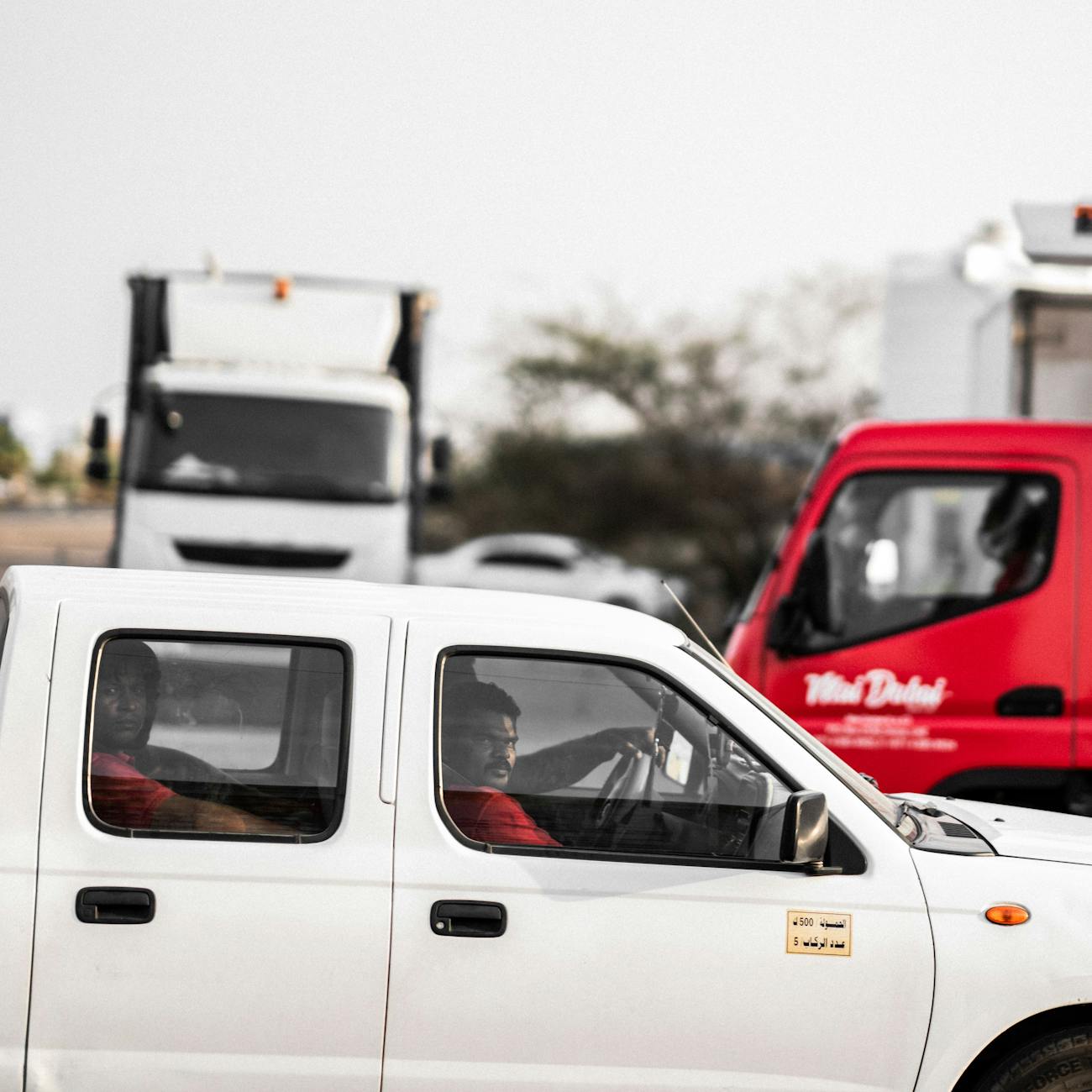 Captured scene of city traffic, highlighting cars and trucks in motion on a busy road.